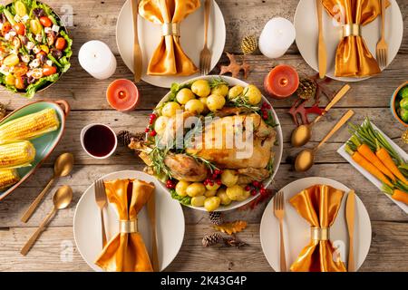 Vista dall'alto del tavolo del ringraziamento con tacchino arrosto, verdure, candele e decorazione autunnale Foto Stock