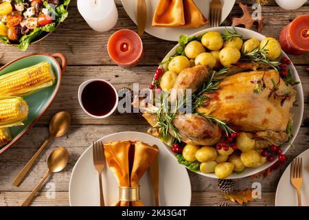 Vista dall'alto del tavolo del ringraziamento con tacchino arrosto, verdure, candele e decorazione autunnale Foto Stock