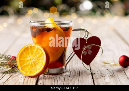 Immagine di una tazza di tè con spezie e decorazioni di limone e natale su backgorund in legno Foto Stock