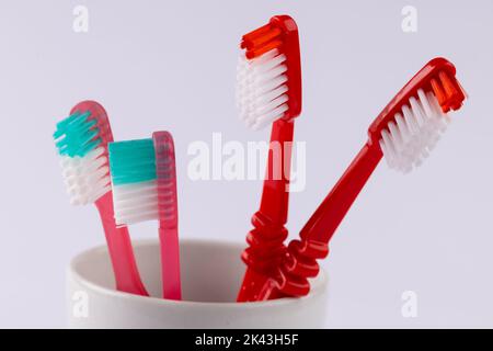 Immagine degli spazzolini da denti nella tazza su sfondo grigio Foto Stock