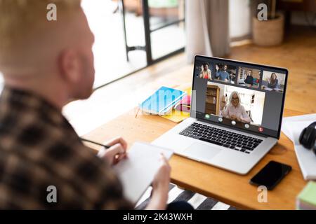 Albino uomo d'affari afro-americano che ha videochiamata con i colleghi. Concetto globale di business e interfaccia digitale, immagine composita digitale. Foto Stock