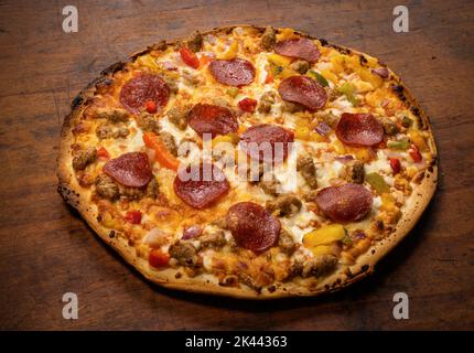 Tutta la pizza sul tavolo in legno Foto Stock