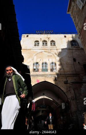 Un uomo palestinese che cammina nel quartiere musulmano della città vecchia di Gerusalemme. Foto Stock