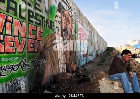 Yasser Arafat murale sulla barriera muraria israeliana vicino al checkpoint Kalandia tra Gerusalemme e Ramallah. Foto Stock