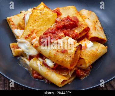 Pasta italiana Paccheri alla Sorrentina con salsa di pomodoro e mozzarella. Primo piano. Foto Stock