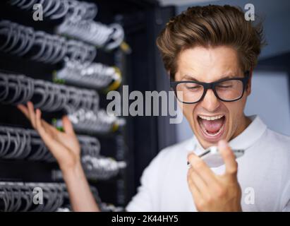 Prendersi cura delle proprie esigenze di rete. Un tecnico arrabbiato urla al suo telefono. Foto Stock