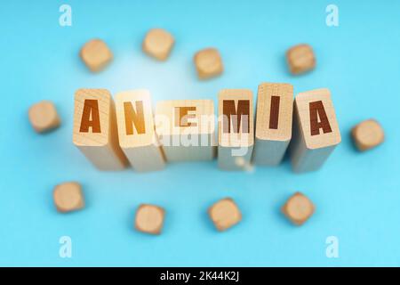 Concetto di medicina. Su sfondo blu, cubetti di legno e Jenga con l'iscrizione - ANEMIA Foto Stock