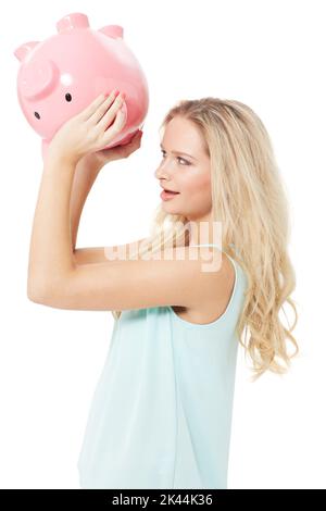 Im si è rotto... Una giovane donna graziosa che scuote la sua banca del piggy e domandandosi dove tutti i moneys sono andato. Foto Stock