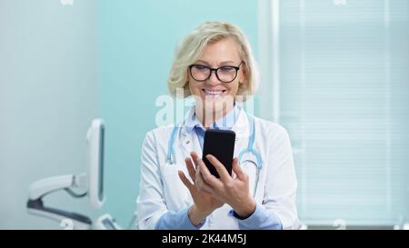 Il medico esamina le cartelle cliniche in ufficio ecografico Foto Stock