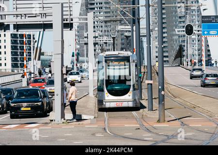 Rotterdam, Paesi Bassi - 8 maggio 2022: Persone che attraversano e veicoli che guidano sul ponte Erasmusbrug sul fiume New Meuse. Giorno di sole di primavera Foto Stock