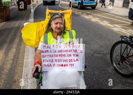 Nizza, Francia. 29th Set, 2022. Una donna del movimento dei giubbotti gialli su una sedia a rotelle tiene un cartello anti-guerra durante la dimostrazione. Una manifestazione è stata organizzata per chiedere salari più alti e contro la riforma delle pensioni su invito dell'Unione CGT a Nizza. Credit: SOPA Images Limited/Alamy Live News Foto Stock