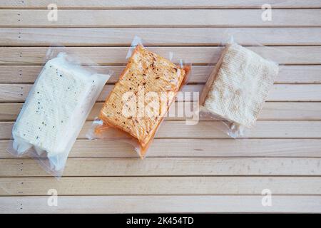 Vegan cibo a base di soia assortito, tofu cagliata di fagioli sul tavolo di legno. Prodotto naturale alternativo. Foto Stock