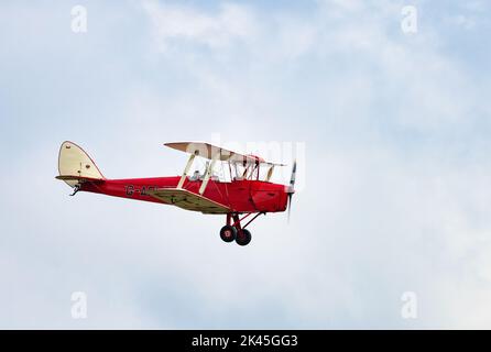 Vecchio biplano; Un aereo d'epoca de Havilland DH82A che vola, noto anche come Tiger Moth, un biplano britannico 1930s; all'Imperial War Museum Duxford Airshow, Regno Unito Foto Stock