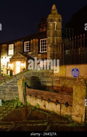 Haworth, West Yorkshire, Regno Unito. 19th Century Stocks sulla Main Street di notte Foto Stock