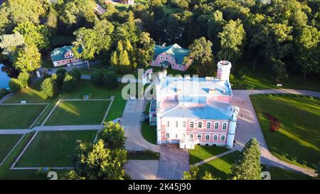 Vista aerea del Palazzo Birinu. Castello lettone sul lago con Nizza Giardino, Drone Shot. Birini Manor, Regione di Vidzeme, Lettonia. Soleggiato Autunno Foto Stock