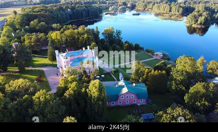 Vista aerea del Palazzo Birinu. Castello lettone sul lago con Nizza Giardino, Drone Shot. Birini Manor, Regione di Vidzeme, Lettonia. Soleggiato Autunno Foto Stock