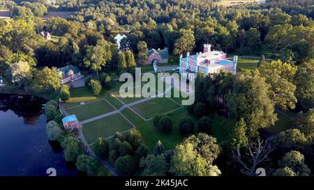 Vista aerea del Palazzo Birinu. Castello lettone sul lago con Nizza Giardino, Drone Shot. Birini Manor, Regione di Vidzeme, Lettonia. Soleggiato Autunno Foto Stock