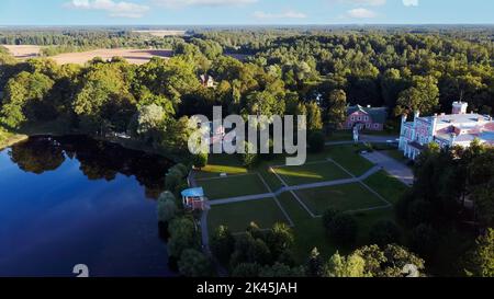 Vista aerea del Palazzo Birinu. Castello lettone sul lago con Nizza Giardino, Drone Shot. Birini Manor, Regione di Vidzeme, Lettonia. Soleggiato Autunno Foto Stock