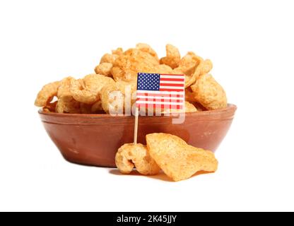 Mucchio di pelli di maiale fritte isolato su sfondo bianco con bandiera degli Stati Uniti Foto Stock