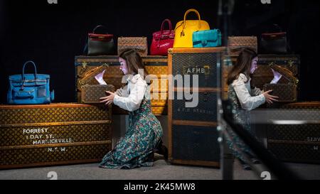 Londra, Regno Unito. 30 settembre 2022. Un membro dello staff esamina un Louis Vuitton: A Monogram Boite Flacons Train Case, 1990s, (Est. €£1.000 - €1.500) in anteprima di Bonhams prossime borse da designer e vendita di moda. Oltre 250 lotti di borse, pronti per l'uso e bigiotteria, tra cui articoli di Hermès, Louis Vuitton, Chanel e Dior, saranno messi all'asta presso le gallerie di Bonhams Knightsbridge il 4 ottobre. Credit: Stephen Chung / Alamy Live News Foto Stock