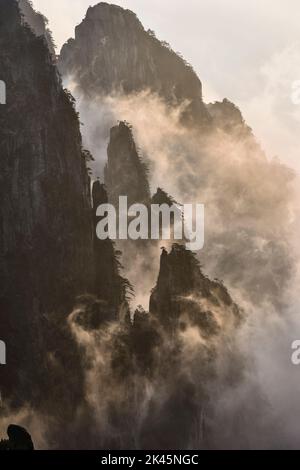 Le ripide cime frastagliate di granito delle Huangshan Mountains, le Yellow Mountains, nebbia e nuvole nelle valli tra le cime. Foto Stock