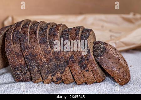 Donna che affetta pane di segale su un tagliere di legno. Un pezzo di  parmigiano, pomodori ciliegini, un piccolo camioncello di formaggio in  primo piano. Moody nat Foto stock - Alamy