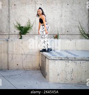 Sequenza di colpi di giovane donna nera felice che saltano fuori di un camminamento Foto Stock