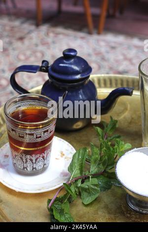 Un bicchiere di tè, una teiera, una menta su un tavolo al caffè El Fishawi, Khan al Khalili Bazaar, il Cairo, Egitto Foto Stock