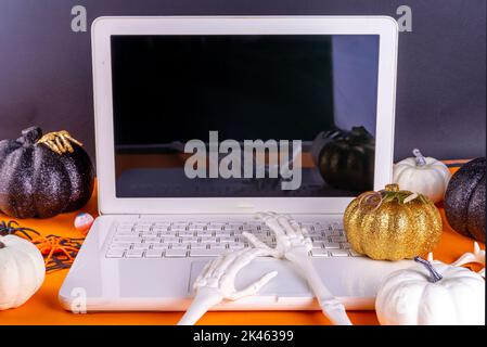 Divertente posto di lavoro di Halloween con il laptop piatto. Ufficio Corporation Halloween festa invito, blogger sfondo di festa d'autunno. Notebook bianco con ha Foto Stock