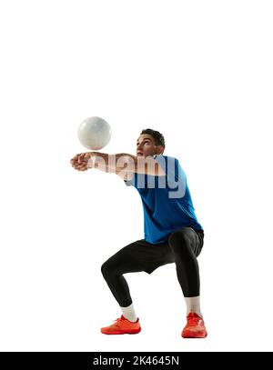 Ricevere la palla. Un allenatore di pallavolo con palla isolata su sfondo bianco studio. Sport, palestra, sport di squadra, competizione, emozioni Foto Stock