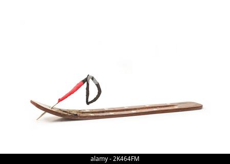 Bastone incenso che brucia su un supporto di legno su uno sfondo bianco con spazio di copia Foto Stock