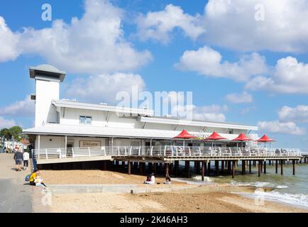 La gente sul lungomare di Felixstowe cammina verso il molo di Felixstowe e la spiaggia sabbiosa di Felixstowe Beach Felixstowe Suffolk Inghilterra UK GB Europa Foto Stock