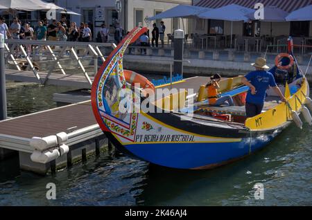 Aveiro, Portogallo - 14 agosto 2022: I turisti in coda per imbarcarsi su una gondola ormeggiata Foto Stock