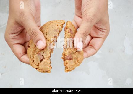 persona che mangia a mano biscotti dolci Foto Stock
