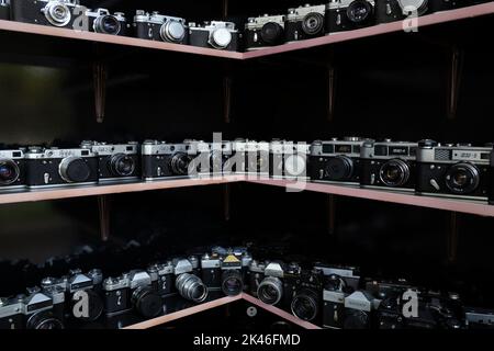 SAMARCANDA, UZBEKISTAN - 12 SETTEMBRE 2022: Collezione di vecchie telecamere sovietiche sugli scaffali. Un frammento dell'interno di un negozio di attrezzature fotografiche Foto Stock