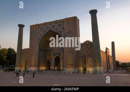 SAMARCANDA, UZBEKISTAN - 13 SETTEMBRE 2022: Antica Madrasa Ulugbek su Piazza Registan al tramonto Foto Stock