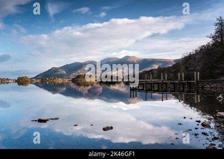 Ashness Bridge Jetty e il Massiccio Skidded riflesso in Derwentwater in una bella mattinata d'estate, English Lake District Foto Stock