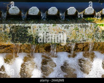 Acque trattate che fluiscono attraverso uno stramazzo in un trank secondario in un impianto di trattamento delle acque reflue Foto Stock