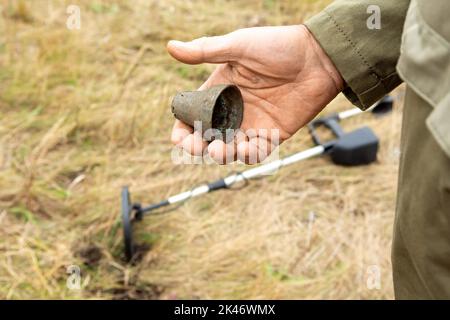 Uomo con rilevatore di metalli elettronico che lavora all'esterno. Fotografia ravvicinata di ricerca di oggetti antichi processo. Foto Stock