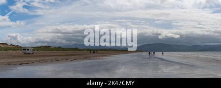 Inch Strand, Irlanda - 5 agosto, 2022: Guida a motore lungo l'infinita spiaggia sabbiosa di Inch Strand nella baia di Dingle con la bassa marea Foto Stock