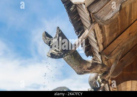 Vecchia grondaia di legno in un villaggio alpino Foto Stock