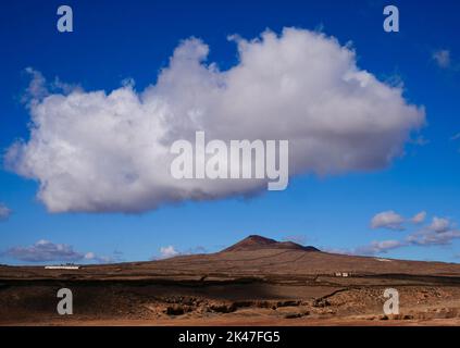 Paesaggio solitario di vulcano con cielo blu e grande nuvola bianca Foto Stock