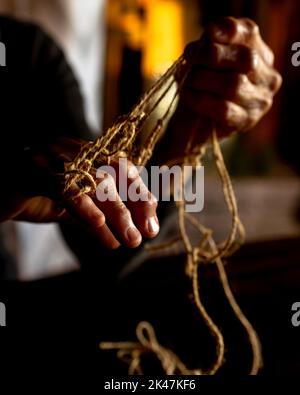 Mani di vecchia donna con malattia di poliartrite. Corde di tela sulle dita della signora anziana, marionette. Foto di alta qualità Foto Stock