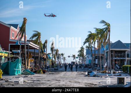 A Coast Guard Air Station Clearwater MH-60 Jayhawk vola in alto, mentre il personale assegnato alle squadre di Gulf, Atlantic e Pacific Strike ricerca persone non contabilizzate a Fort Myers Beach, Florida il 29 settembre 2022. Le squadre della Guardia di costa della National Strike Force si sono mobilitate nelle aree colpite dall'uragano Ian per eseguire la ricerca urbana e il salvataggio. (STATI UNITI Guardia costiera foto di Petty Officer 3rd Classe Gabriel Wisdom) Foto Stock