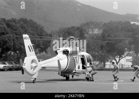 I tirocinanti salgono a bordo di un elicottero Aerospatiale Dauphin, gestito da Hong Kong's Government Flying Services, pronto per il decollo presso la Police Training School, Hong Kong 1984 Foto Stock