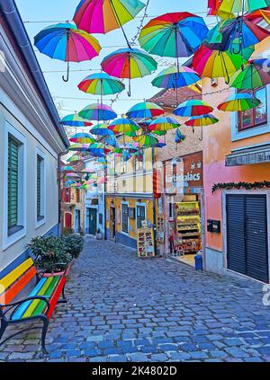 SZENTENDRE, UNGHERIA - 24 FEBBRAIO 2022: Gli ombrelli arcobaleno sulla stretta strada turistica, il 24 febbraio a Szentendre Foto Stock