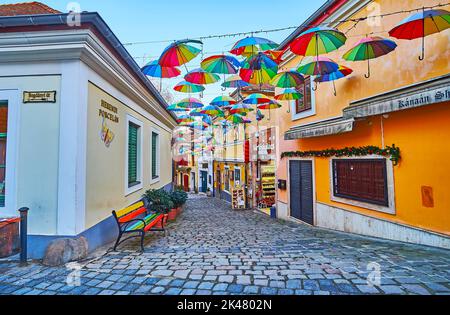 SZENTENDRE, UNGHERIA - 24 FEBBRAIO 2022: Tenda di ombrelloni arcobaleno decorare la stretta strada turistica, il 24 febbraio a Szentendre Foto Stock