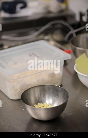 chef che prepara per glassa una torta all'acqua lilla nel laboratorio professionale della cucina Foto Stock