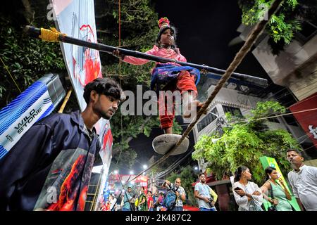 Kolkata, India. 30th Set, 2022. Una bambina cammina su una corda durante un'esibizione per guadagnare un po' di soldi di fronte a un Pandal Durgapuja (luogo temporaneo per il culto) a Kolkata. (Foto di Avishek Das/SOPA Images/Sipa USA) Credit: Sipa USA/Alamy Live News Foto Stock