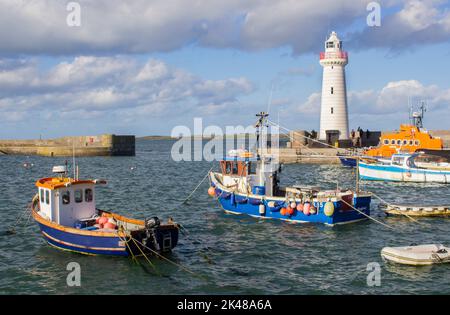 30 settembre 2022 le barche ormeggiate nel porto di Donaghadee, Irlanda del Nord, sotto la luce solare soffusa dei primi mesi dell'autunno, sotto l'ombra del faro locale. Foto Stock